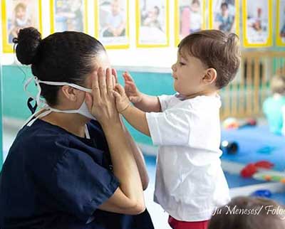 Educadora interagindo com criança - Berçário Uniepre