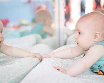 Criança interagindo no espelho - Berçário Uniepre