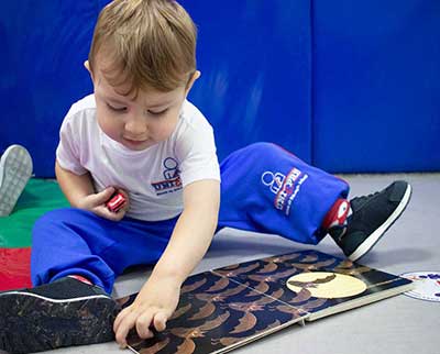 Criança observando livro ilustrado - Educação Infantil Uniepre