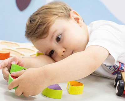 Criança explorando objetos de madeira - Educação Infantil Uniepre