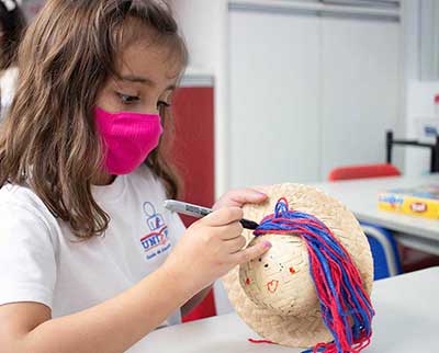 Criança decorando elemento junino - Educação Infantil Uniepre