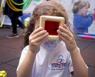 Criança investigando objeto - Educação Infantil Uniepre