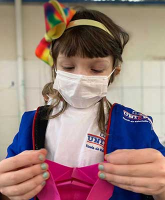 Criança compondo origami - Ensino Fundamental Uniepre