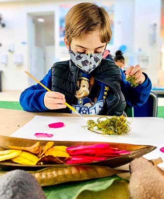 Criança em atividade artística com elementos naturais - Ensino Fundamental Uniepre